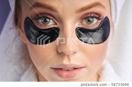 Beautiful natural girl with cosmetic black patches under eyes Beautiful natural girl with cosmetic black patches under eyes 58733698