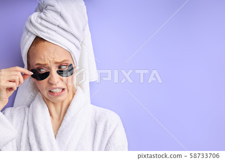 Young beautiful woman removing black patch from under eye 58733706