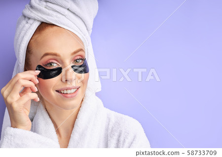 Young beautiful girl after the shower looks thoughtfully aside, isolated, beauty procedures Young beautiful girl after the shower looks thoughtfully aside, isolated, beauty procedures 58733709