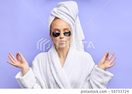 Beautiful caucasian woman wears collagen black patches under eyes in bathrobe Beautiful caucasian woman wears collagen black patches under eyes in bathrobe 58733724
