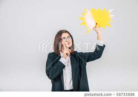 Portrait of an excited young business woman raising up empty sparkle-like speech bubble, looking at 58733886