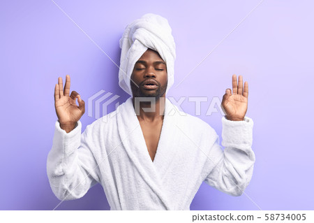 Peaceful african man doing yoga and meditate iolated over purple hite background 58734005