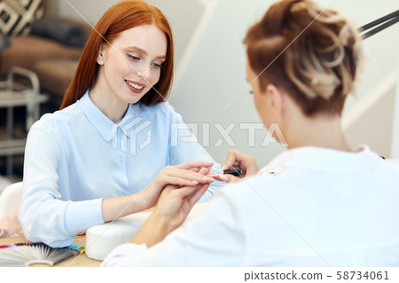 Nail Care And Manicure. Redhead woman came to manicure salon Nail Care And Manicure. Redhead woman came to manicure salon 58734061