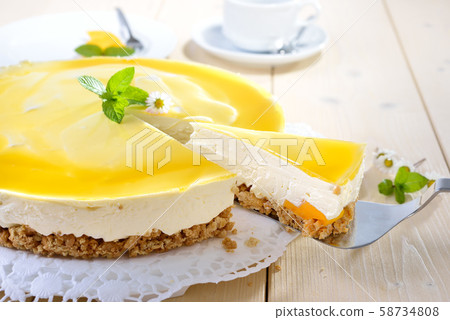 Fresh cheesecake with mango fruit and glaze, the flan case made of cookie crumbs 58734808