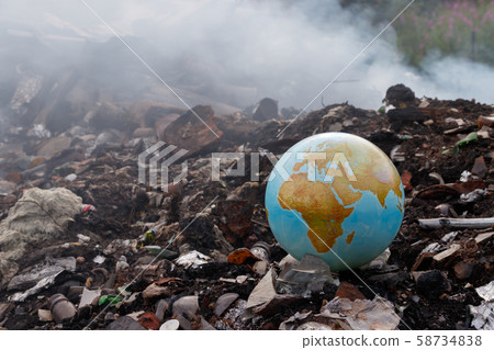 Concept to the problem of the environment - burning of garbage. Incineration plants are harmful to the environment. Planet earth is thrown into the trash. Garbage burns, smoke comes. Toxic dioxins. Concept to the problem of the environment - burning of garbage. Incineration plants are harmful to the environment. Planet earth is thrown into the trash. Garbage burns, smoke comes. Toxic dioxins. 58734838