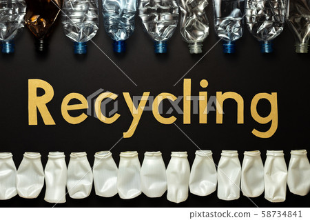 Recycling concept. The word recycled from cardboard letters. Crumpled bottles made of polyethylene terephthalate (PET) and high density polyethylene (PEHD or HDPE). Marking plastic number 1 and 2 58734841