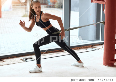 Female gymnast training legs with elastic ribbon workout fitness 58734853