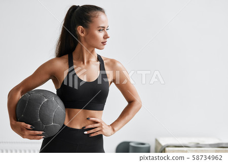 Caucasian young fitness girl exercising with fitness ball Caucasian young fitness girl exercising with fitness ball 58734962