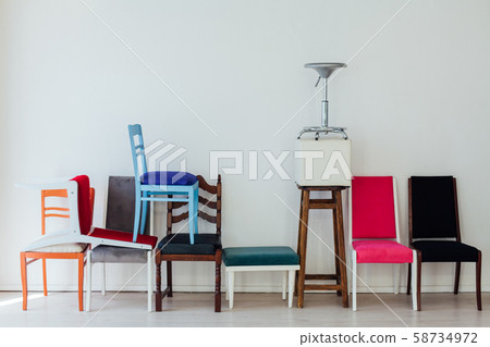 lots of different chairs in the interior of an empty white room 58734972