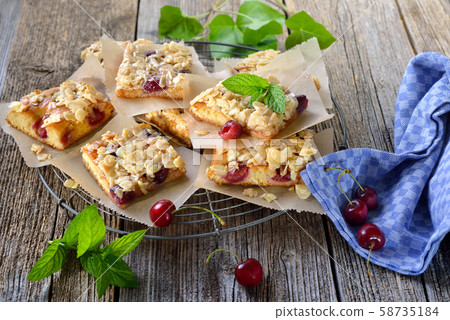 Fresh Austrian yeast cake with cherries and crunchy almond caramel served on a shabby cooling rack 58735184