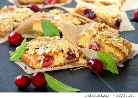 Fresh Austrian yeast cake with cherries and crunchy almond caramel served on a shabby cooling rack 58735185
