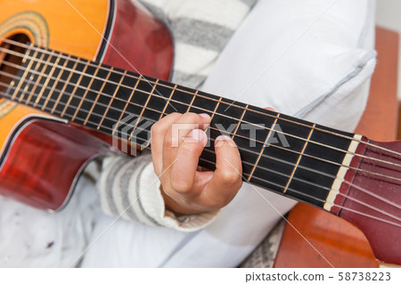Hand of a little girl learning to play the guitar 58738223