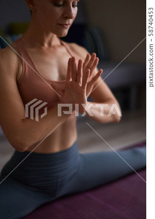 Young woman doing yoga exercise at home in split 58740453