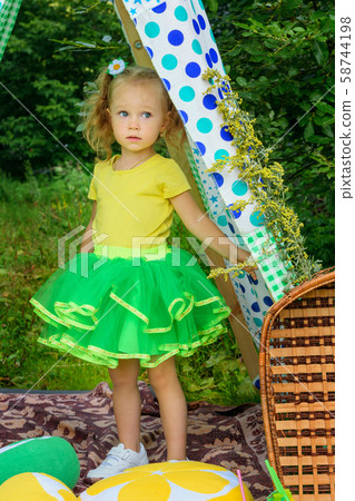 Girl with pillows, lemons, oranges in tent in park 58744198