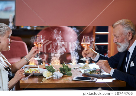 Mature couple fining meal together at restaurant Mature couple fining meal together at restaurant 58744766