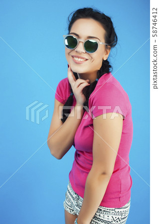 young pretty teenage modern hipster girl posing emotional happy on blue background, lifestyle people young pretty teenage modern hipster girl posing emotional happy on blue background, lifestyle people 58746412