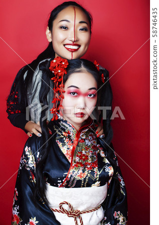 two pretty geisha girls friends: modern asian woman and traditional wearing kimono posing cheerful two pretty geisha girls friends: modern asian woman and traditional wearing kimono posing cheerful 58746435