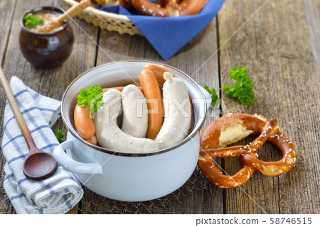 Hot Bavarian white sausages and wieners in an enamel cooking pot with pretzels and sweet mustard Hot Bavarian white sausages and wieners in an enamel cooking pot with pretzels and sweet mustard 58746515