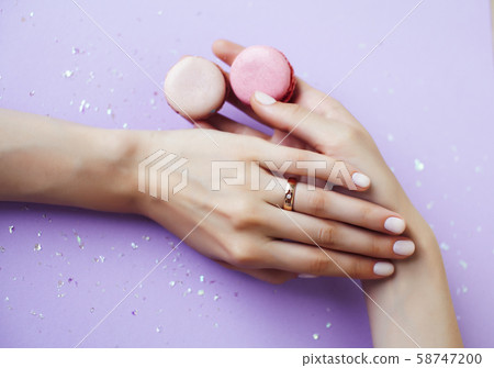 woman hands with manicure holding macaroons girl stuff on lilac background, cosmetic lifestyle woman hands with manicure holding macaroons girl stuff on lilac background, cosmetic lifestyle 58747200
