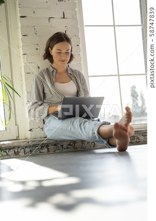 Cute young woman looking at her laptop 58747839