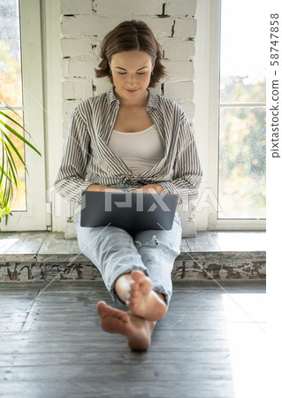 Busy young lady typing on her laptop Busy young lady typing on her laptop 58747858