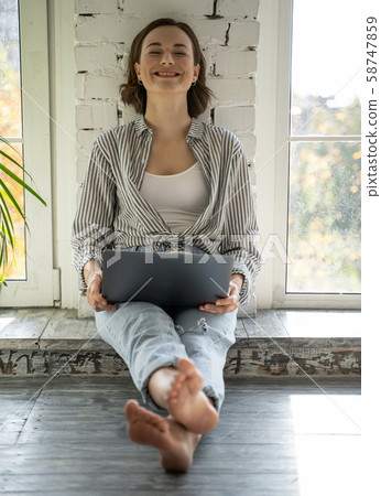 Smiling pretty young female with a laptop Smiling pretty young female with a laptop 58747859