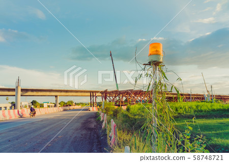Alarm lights for the construction of a car bridge across the irrigation canal in the evening. Selective focus on alarm lights. Alarm lights for the construction of a car bridge across the irrigation canal in the evening. Selective focus on alarm lights. 58748721
