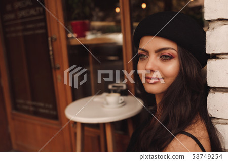 curly woman in retro hat in cafe 58749254