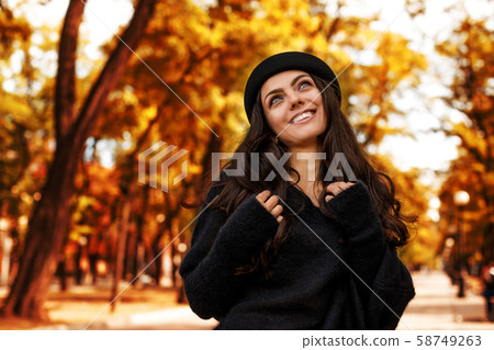 woman in black hat on the background of autumn leaves. 58749263