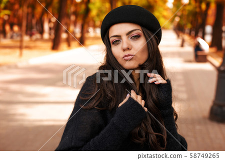 woman in black hat on the background of autumn leaves. woman in black hat on the background of autumn leaves. 58749265