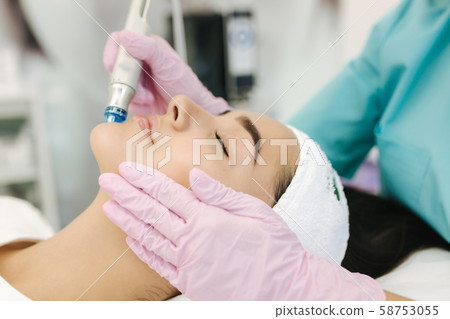 Close-up of woman getting facial hydro microdermabrasion peeling treatment. Female at cosmetic Close-up of woman getting facial hydro microdermabrasion peeling treatment. Female at cosmetic 58753055
