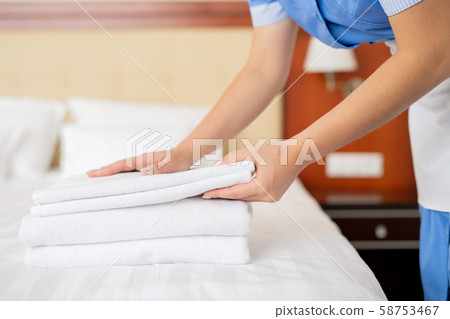 Hands of young contemporary chamber maid making stack of white fresh towels 58753467