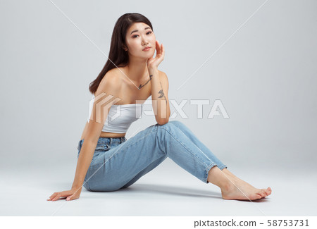 Beautiful young woman wearing white top and blue Beautiful young woman wearing white top and blue 58753731