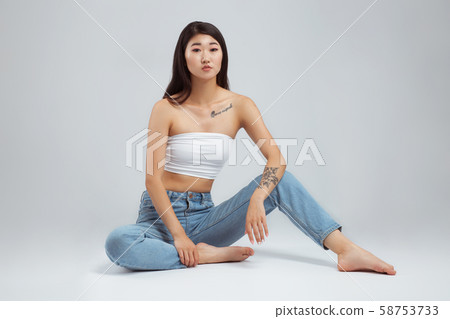 Beautiful young woman wearing white top and blue Beautiful young woman wearing white top and blue 58753733