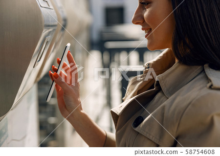 Positive delighted girl holding smartphone in right hand Positive delighted girl holding smartphone in right hand 58754608