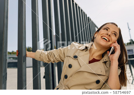 Joyful brunette female smiling while being in all ears Joyful brunette female smiling while being in all ears 58754697