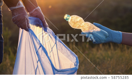 Volunteers collect plastic trash in bags, cleaning the park Volunteers collect plastic trash in bags, cleaning the park 58755285