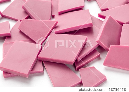 Ruby chocolate pieces, a heap on a white background Ruby chocolate pieces, a heap on a white background 58756458