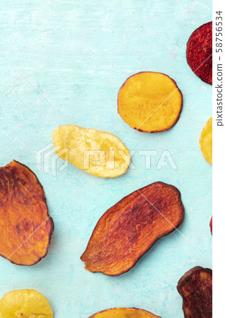 Dried fruit and vegetable chips, shot from above with a place for text. Healthy vegan snack, an Dried fruit and vegetable chips, shot from above with a place for text. Healthy vegan snack, an 58756534