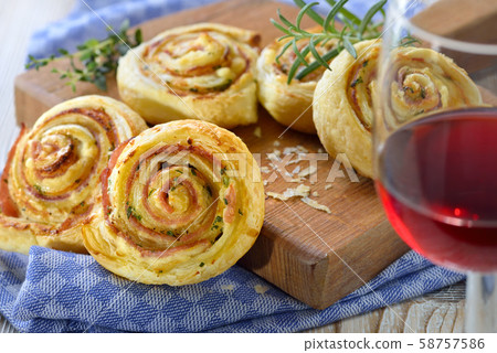 Baked hearty puff pastry rolls with ham, cream cheese, parmesan and herbs; served with red wine Baked hearty puff pastry rolls with ham, cream cheese, parmesan and herbs; served with red wine 58757586