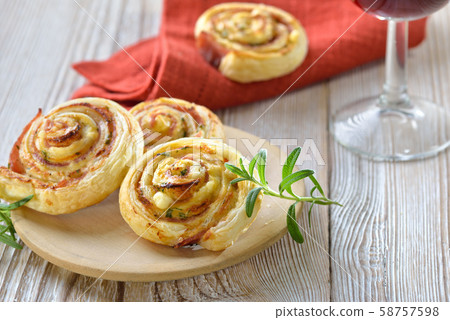 Baked hearty puff pastry rolls with ham, cream cheese, parmesan and herbs; served with red wine  58757598