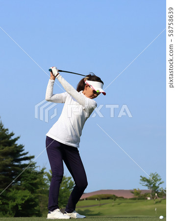 Woman hitting the tee shot Woman hitting the tee shot 58758639
