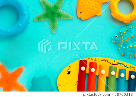Top view on children's educational and music games, frame from multicolored kids toys on light blue Top view on children's educational and music games, frame from multicolored kids toys on light blue 58760318