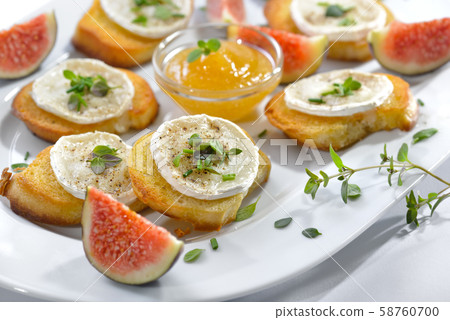 Baked spicy crostini appetizers with goat cheese and fresh herbs with fig mustard and fresh figs Baked spicy crostini appetizers with goat cheese and fresh herbs with fig mustard and fresh figs 58760700