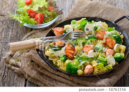 Italian pasta with fried cuts of salmon fillet, horseradish and a sauce of cream Italian pasta with fried cuts of salmon fillet, horseradish and a sauce of cream 58761556