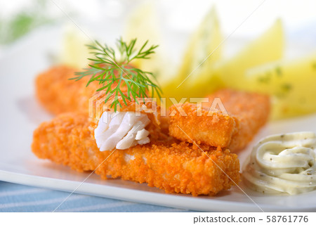Crispy fish fingers of breaded pollack fillet served with parsley potatoes and remoulade sauce Crispy fish fingers of breaded pollack fillet served with parsley potatoes and remoulade sauce 58761776