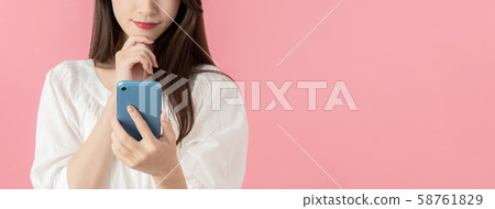 A woman using a smartphone A woman using a smartphone 58761829