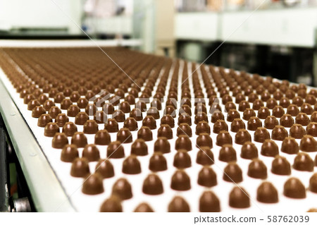 chocolate toppings on the conveyor of a chocolate toppings on the conveyor of a 58762039