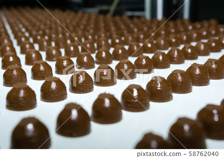 chocolate toppings on the conveyor of a chocolate toppings on the conveyor of a 58762040