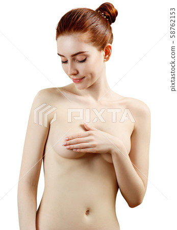 Beautiful naked redhead woman covering her breast against white background. 58762153